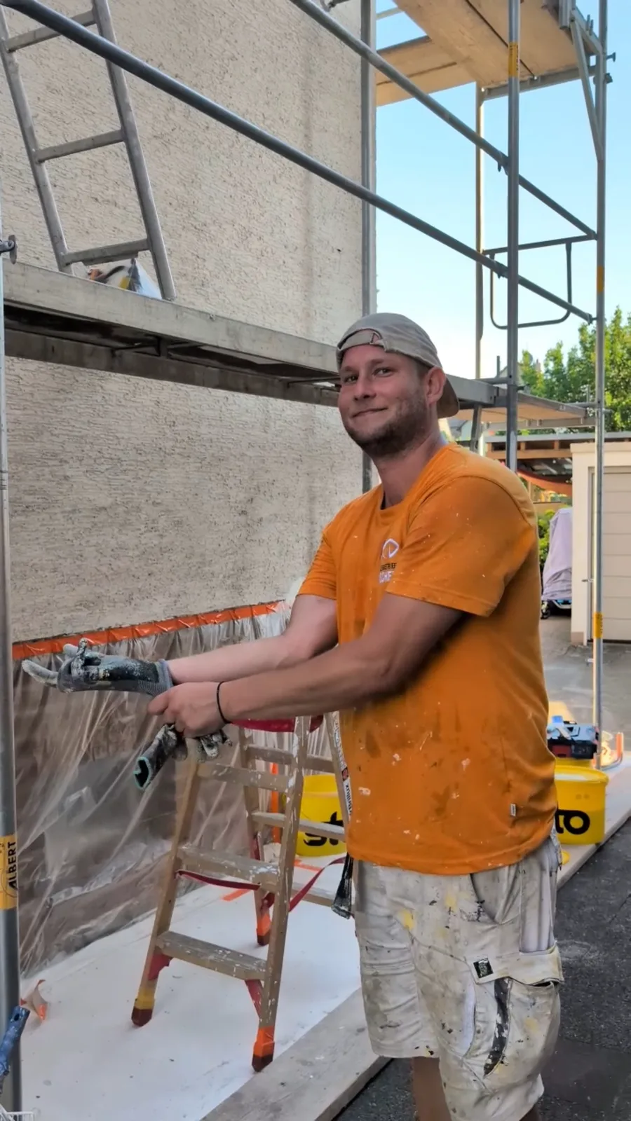 Maler von Malerbetrieb Fischer bereitet eine Fassade am Gerüst vor